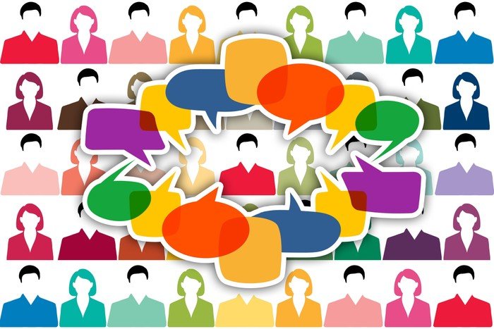 Eine diverse Gruppe von Menschen im Gespräch, als Gemeinschaftsdialog.