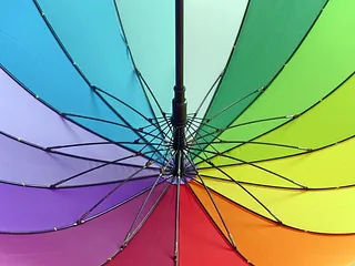  Ein Regenschirm in Regenbogenfarben, der Vielfalt und Gottes Bund symbolisiert.